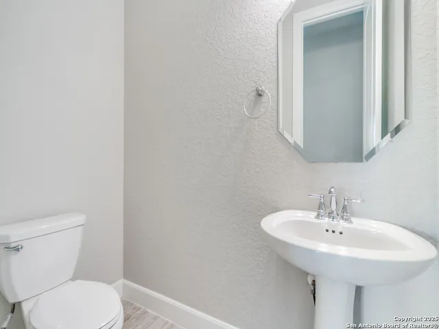 a bathroom with a sink a toilet and mirror