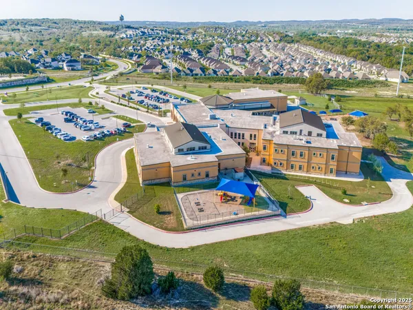 an aerial view of residential houses with outdoor space and trees