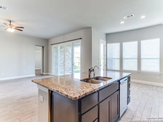 a kitchen with granite countertop kitchen island a sink and a large window