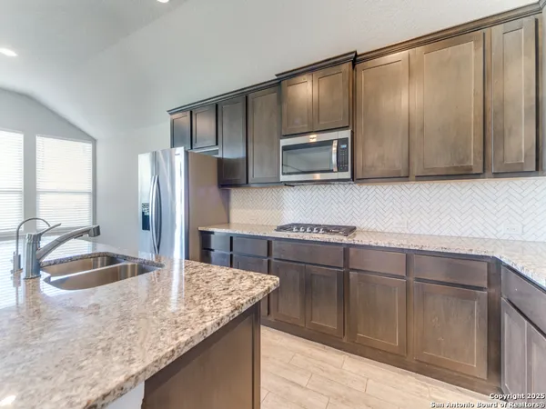a kitchen with stainless steel appliances granite countertop a sink and a microwave