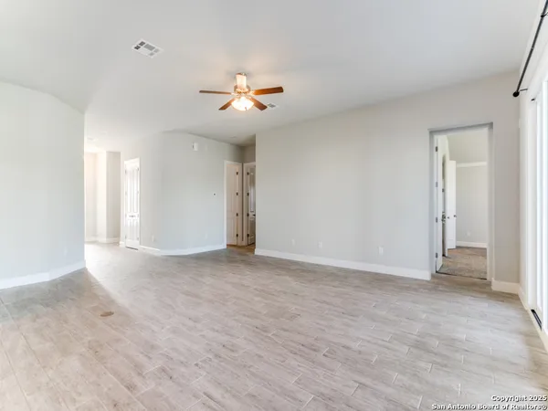 a view of an empty room with a ceiling fan