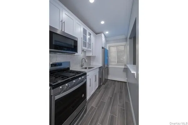 a kitchen with a sink and steel appliances