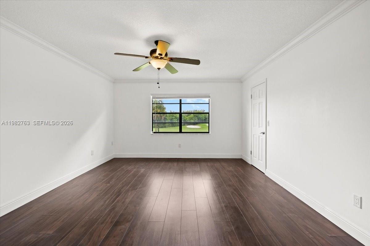 7944 Eastlake Drive, Unit D Boca Raton, FL 33433 - Photo 15 of 29 an empty room with wooden floor chandelier fan and windows