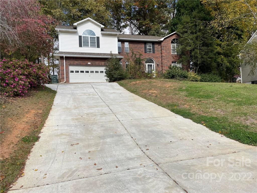 a front view of a house with a yard and trees