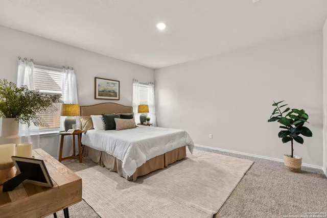 a bedroom with a bed a couch and potted plant