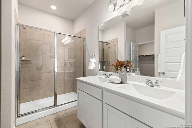 a bathroom with a shower sink and mirror