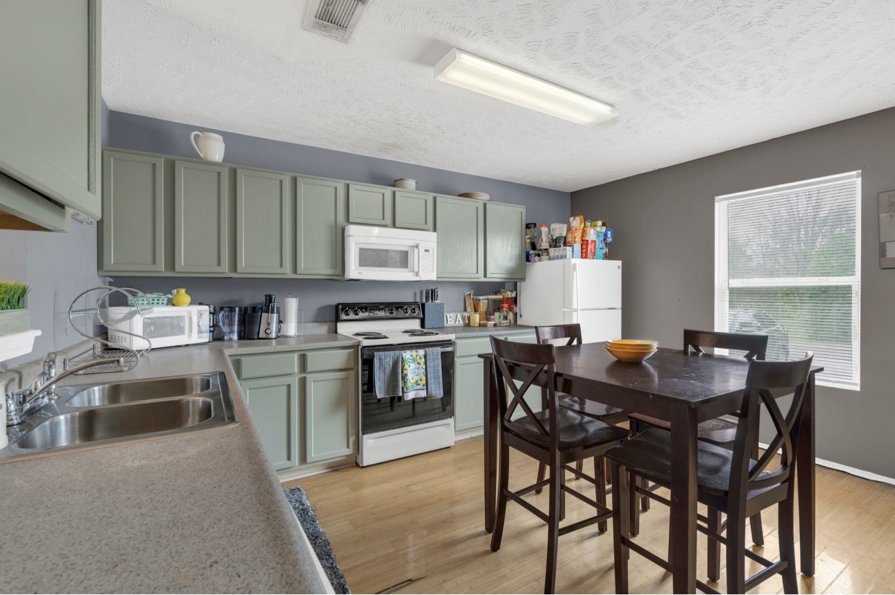 Undisclosed Address Antioch, TN 37013 - Photo 10 of 18 a kitchen with stainless steel appliances kitchen island granite countertop a table chairs a sink dishwasher a stove a dining table and chairs