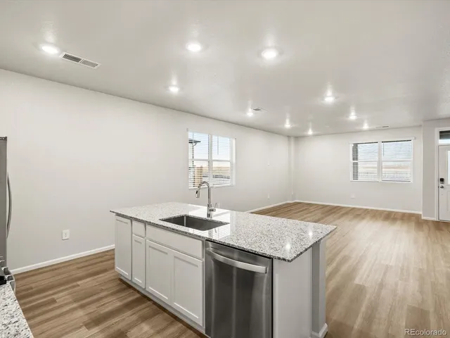 a kitchen with granite countertop cabinets stainless steel appliances a sink and dishwasher