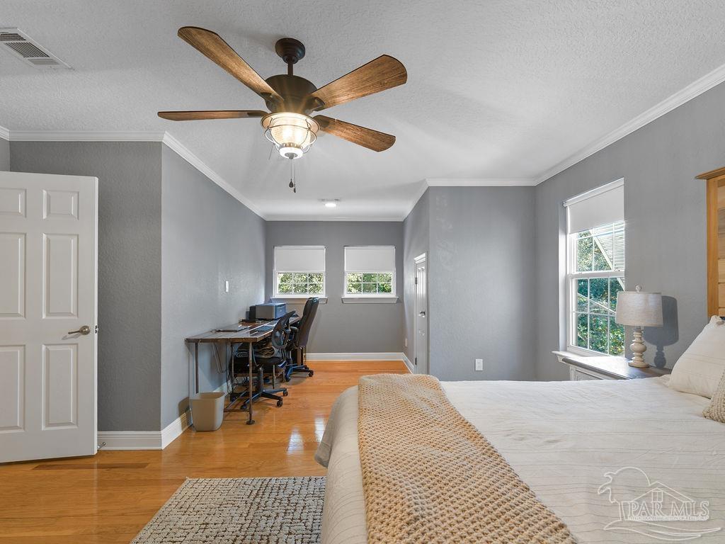 10152 Bittern Drive Pensacola, FL 32507 - Photo 17 of 45 a bedroom with a bed and a chandelier