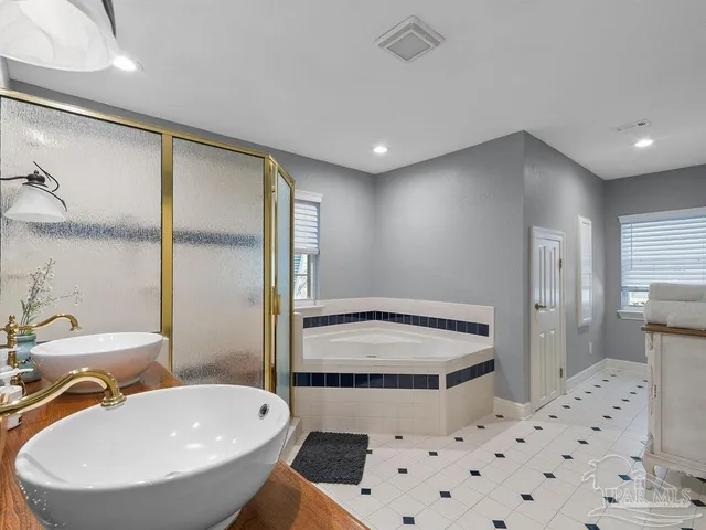 a bathroom with a sink a toilet a mirror and shower