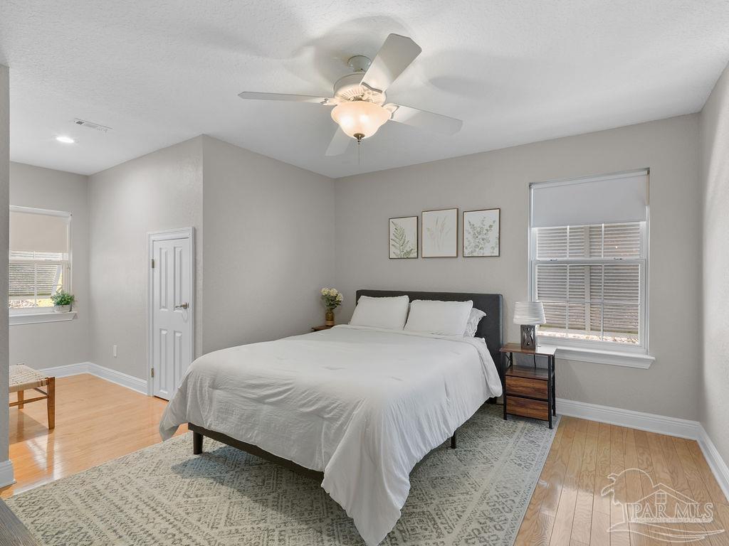 10152 Bittern Drive Pensacola, FL 32507 - Photo 20 of 45 a bedroom with a large bed and a chandelier