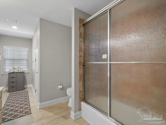 a bathroom with a shower and a glass door