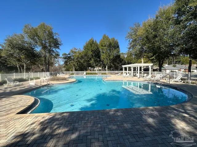 a view of a lake with beach and trees in the background