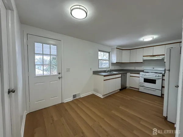 a kitchen with a refrigerator and white cabinets