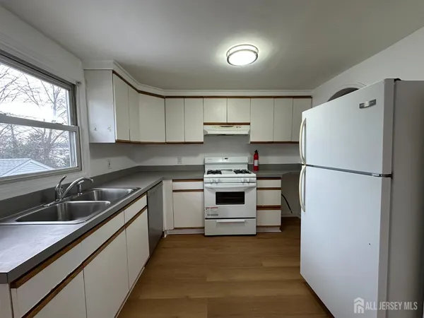 a kitchen with a refrigerator sink and cabinets