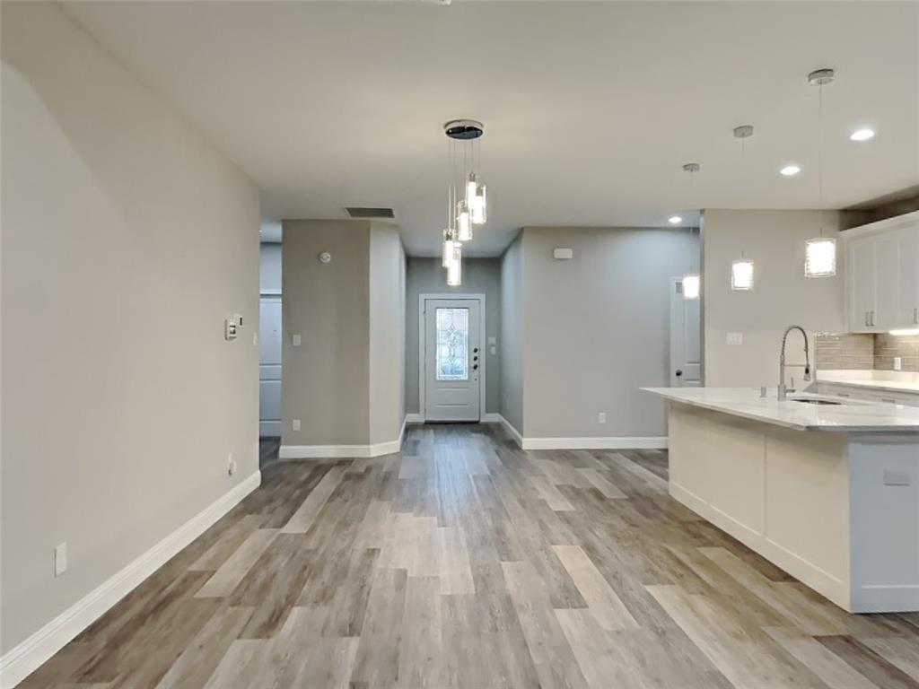 2512 Sharon Street Dallas, TX 75211 - Photo 4 of 17 a view of an empty room and kitchen with wooden floor