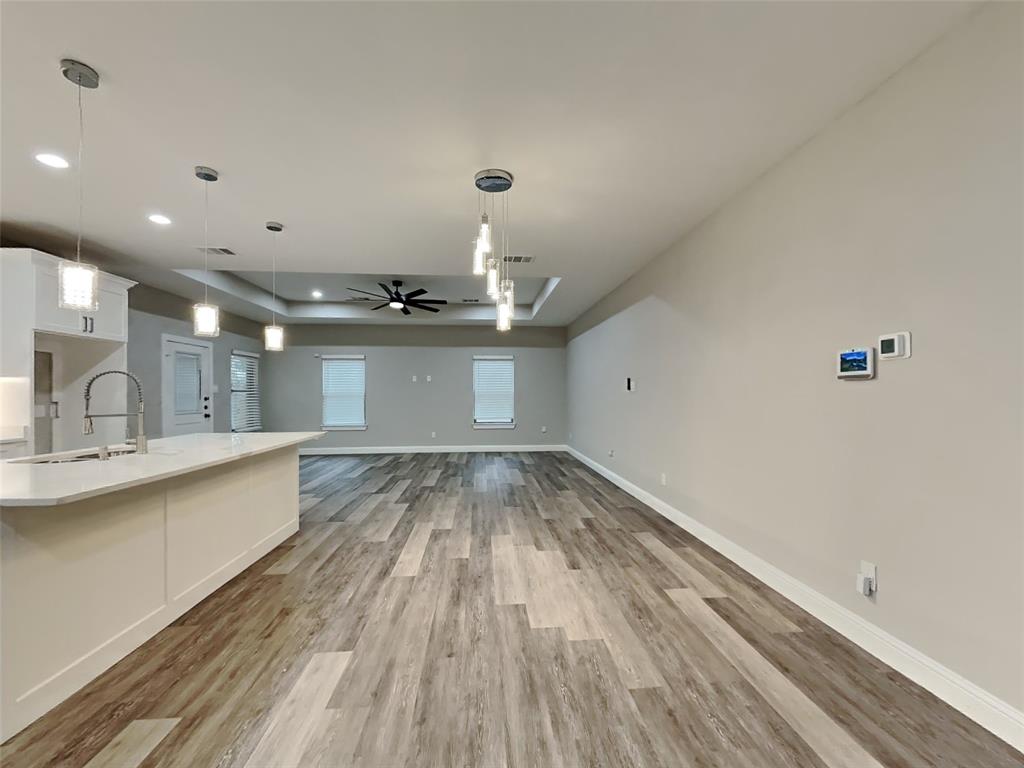 2512 Sharon Street Dallas, TX 75211 - Photo 5 of 17 a view of a kitchen with kitchen island a sink wooden floor and stainless steel appliances