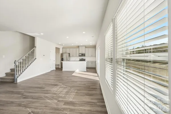 a view of a kitchen with kitchen island white appliances sink and cabinets