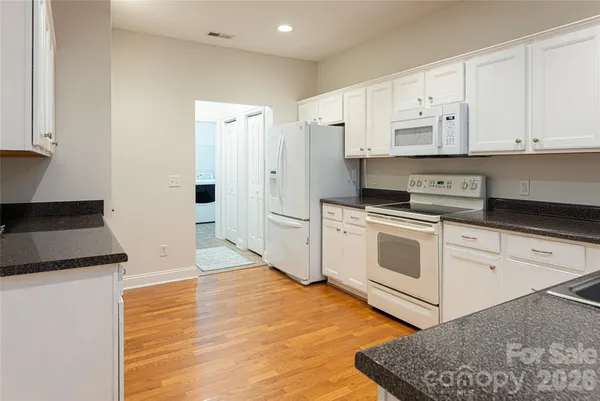 a kitchen with white cabinets and white appliances