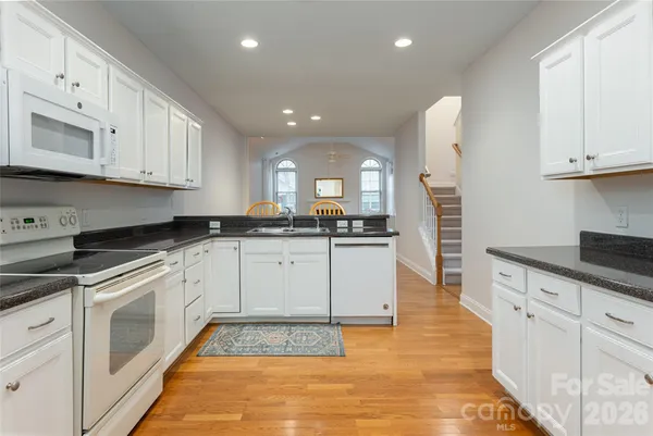 a kitchen with white cabinets and sink