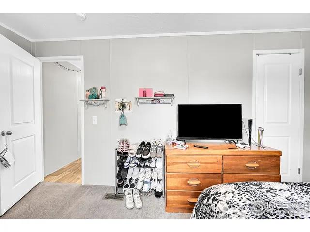 a bedroom with a bed and flat screen tv