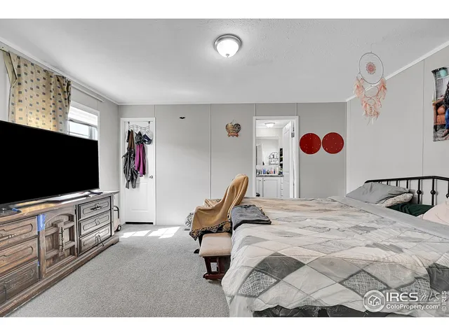 a bedroom with a bed and flat screen tv