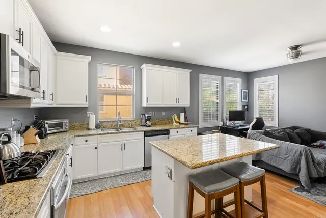 a kitchen with granite countertop a sink and cabinets