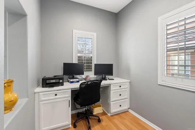 a view of a workspace with furniture and a window