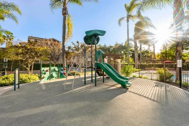 a view of a building with floor to ceiling windows and wooden fence