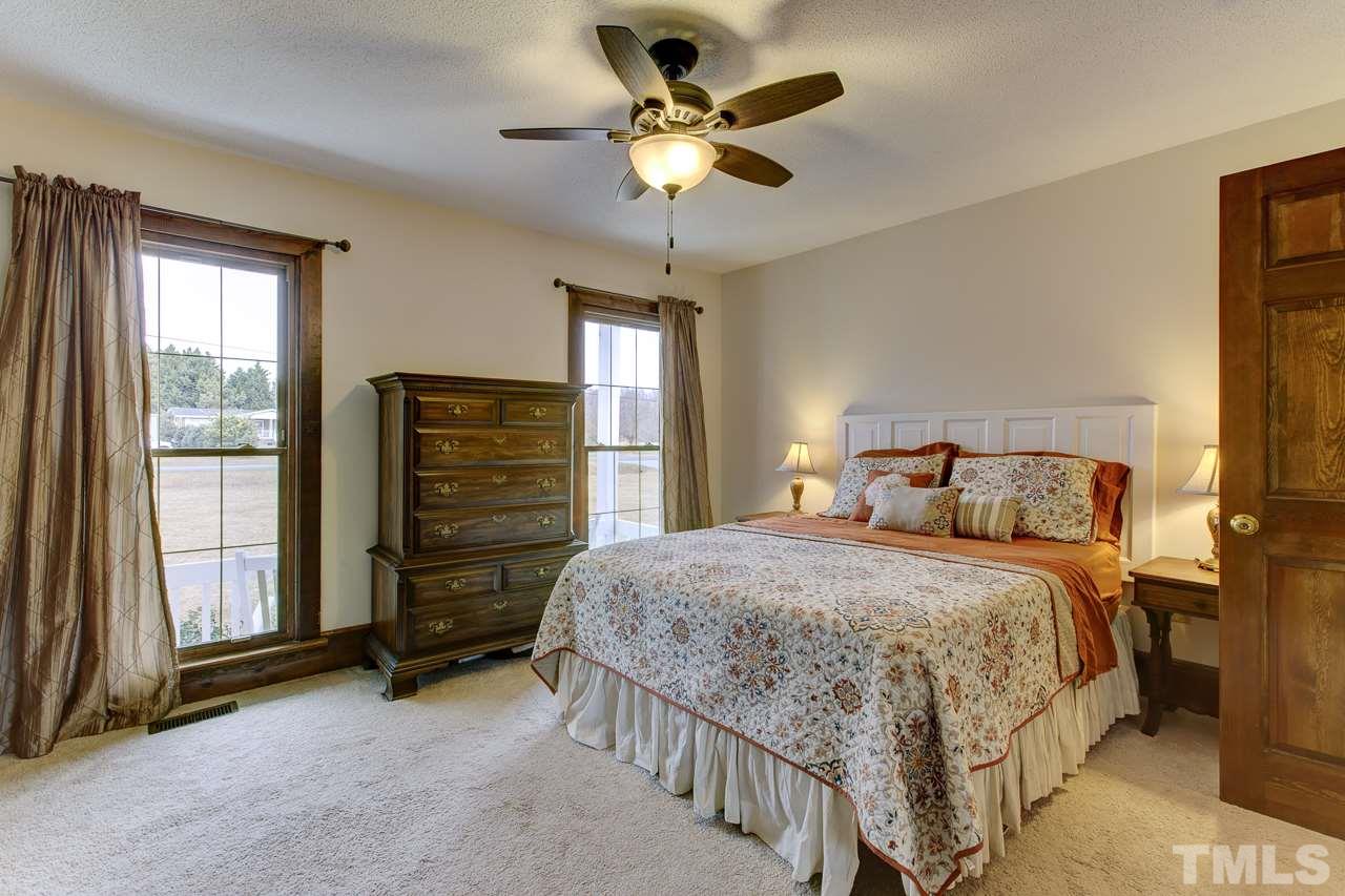 7850 James Austin Road Willow Spring, NC 27592 - Photo 11 of 25 a bedroom with a bed and a chandelier