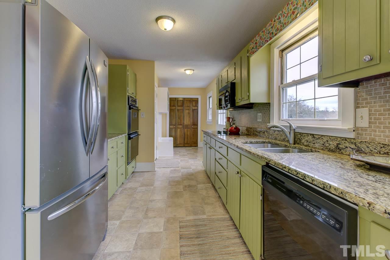 7850 James Austin Road Willow Spring, NC 27592 - Photo 7 of 25 a kitchen with stainless steel appliances granite countertop a sink stove and refrigerator