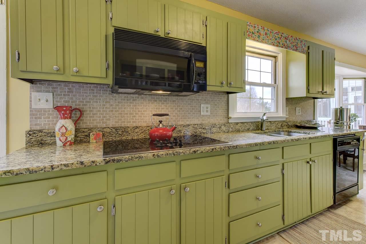 7850 James Austin Road Willow Spring, NC 27592 - Photo 8 of 25 a kitchen with granite countertop cabinets stainless steel appliances a sink and window