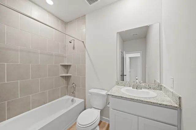 a bathroom with a granite countertop sink a toilet and shower