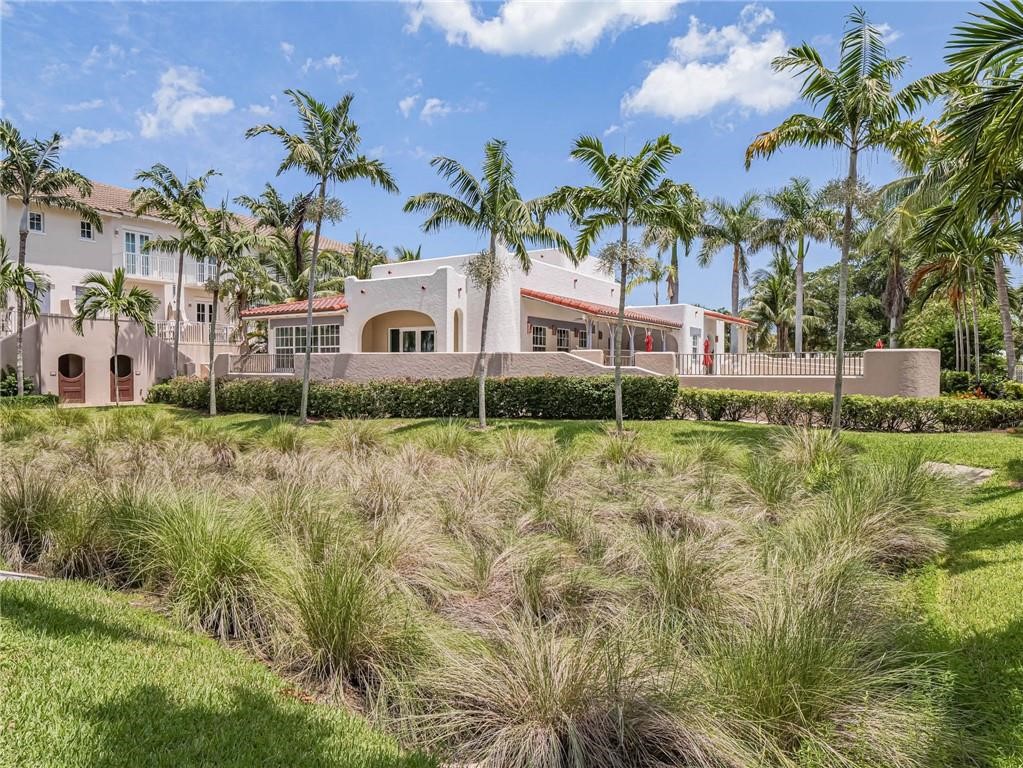 1564 Island Cove Road, Unit 1564 Fort Pierce, FL 34949 - Photo 21 of 26 a front view of a house with a yard and potted plants