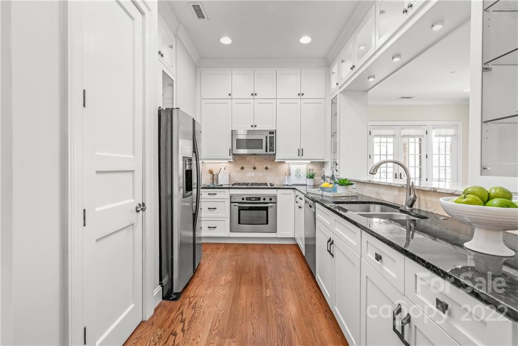 255 Queens Road, Unit 255 Charlotte, NC 28204 - Photo 14 of 32 a large kitchen with stainless steel appliances granite countertop a stove refrigerator and a sink