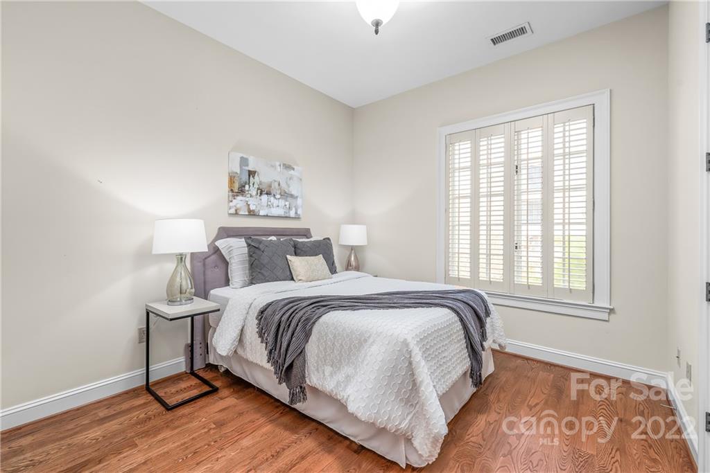 255 Queens Road, Unit 255 Charlotte, NC 28204 - Photo 22 of 32 a bedroom with a bed and wooden floor