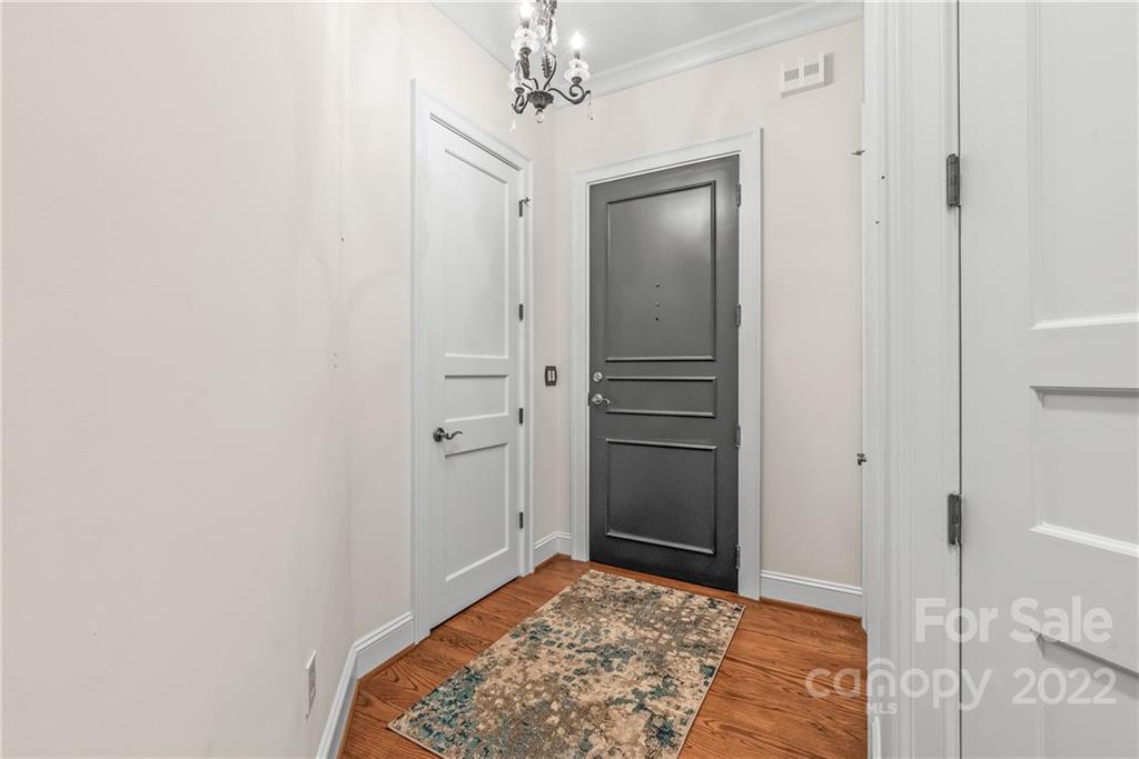 255 Queens Road, Unit 255 Charlotte, NC 28204 - Photo 7 of 32 a view of a hallway with a chandelier and a rug