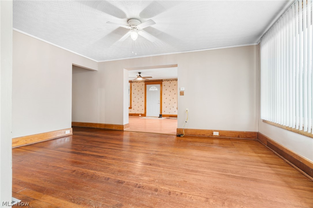 1640 Old Delaware Road Mount Vernon, OH 43050 - Photo 10 of 49 Empty room featuring hardwood / wood-style floors, a ceiling fan, and crown molding