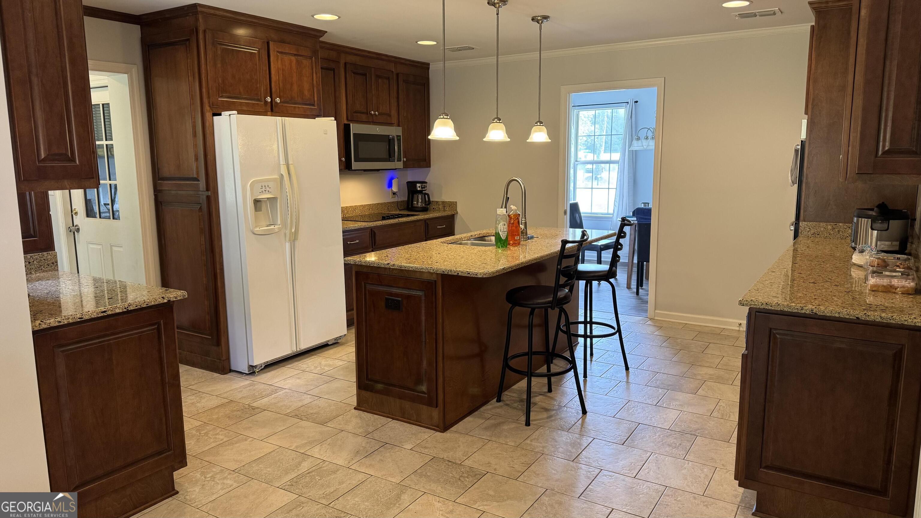 355 Summer Hill Road Thomasville, GA 31757 - Photo 7 of 50 a kitchen with stainless steel appliances a refrigerator a sink a stove a dining table and chairs