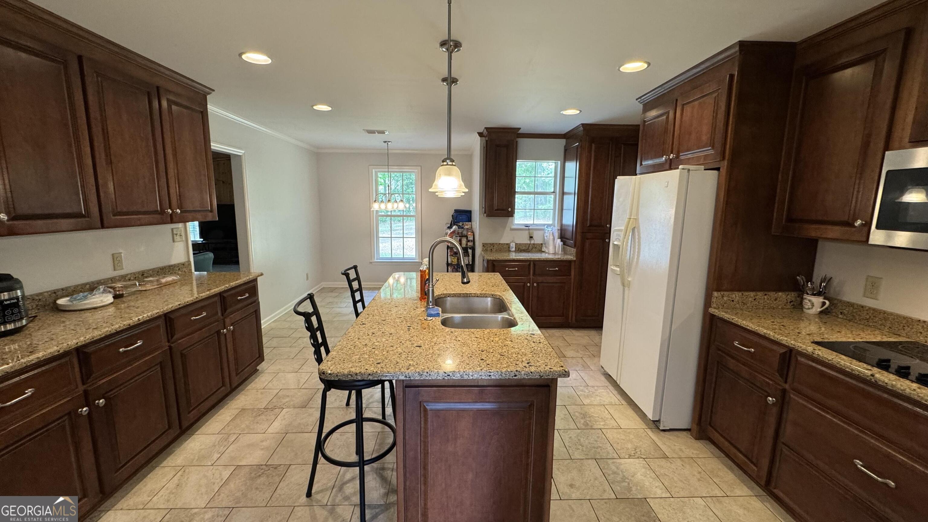 355 Summer Hill Road Thomasville, GA 31757 - Photo 10 of 50 a kitchen with stainless steel appliances granite countertop wooden cabinets a sink a stove a refrigerator and a refrigerator