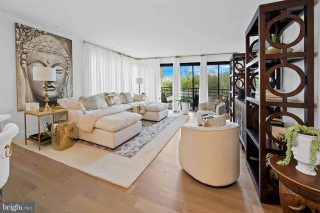 a living room with furniture a floor to ceiling window and outer view
