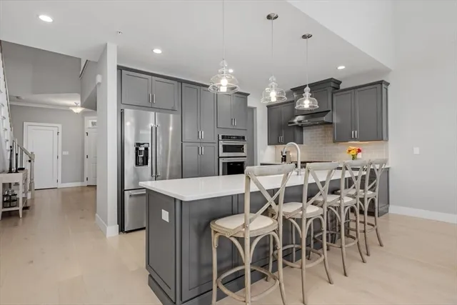 a living room with kitchen island furniture a kitchen view and a refrigerator