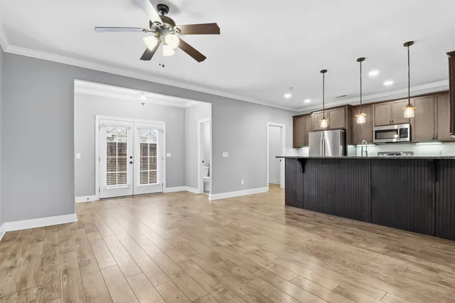 a view of empty room with wooden floor and ceiling fan