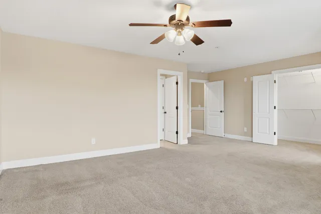 an empty room with a window and a fan