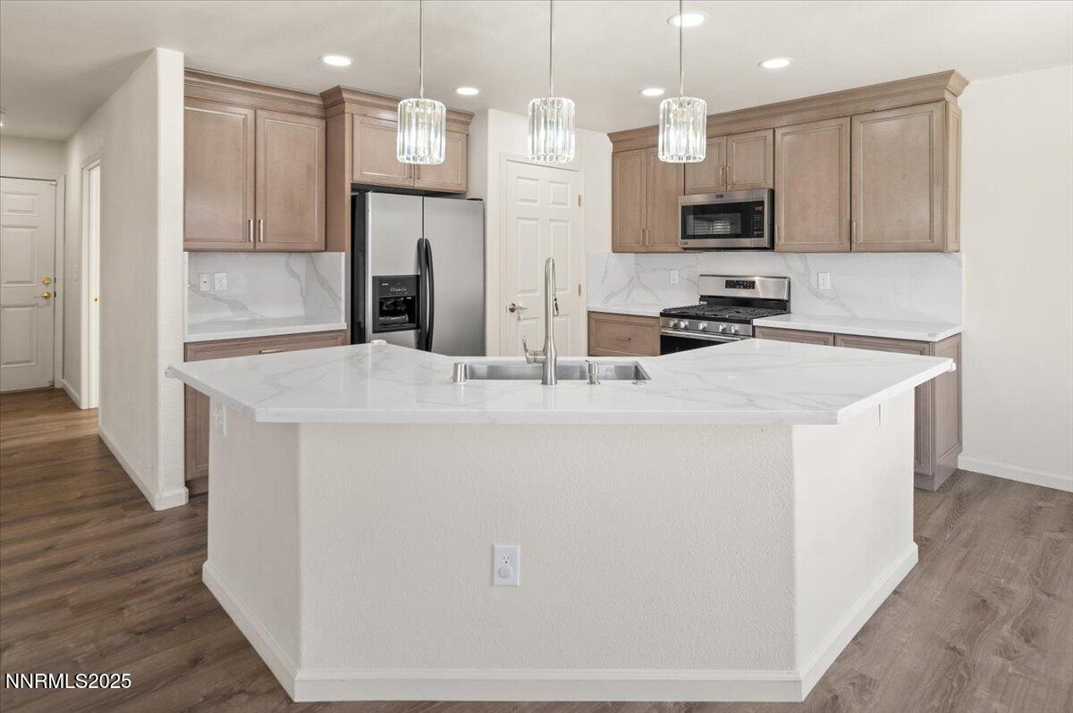 7753 Tulear Street Reno, NV 89506 - Photo 11 of 38 a kitchen with kitchen island a sink stainless steel appliances and cabinets