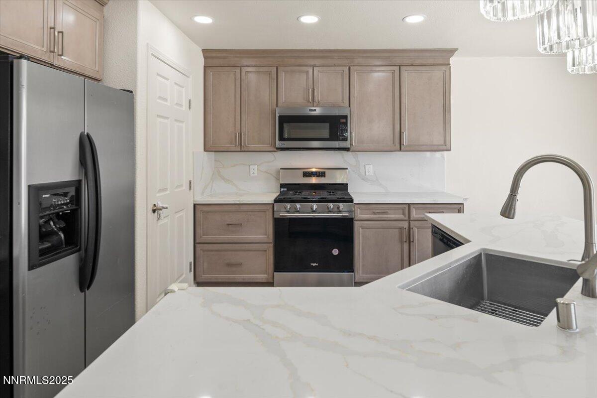 7753 Tulear Street Reno, NV 89506 - Photo 12 of 38 a kitchen with stainless steel appliances granite countertop a refrigerator and a stove top oven