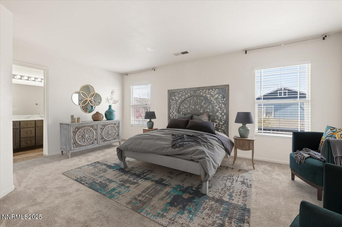 7753 Tulear Street Reno, NV 89506 - Photo 19 of 38 a spacious bedroom with a bed a couch and large windows