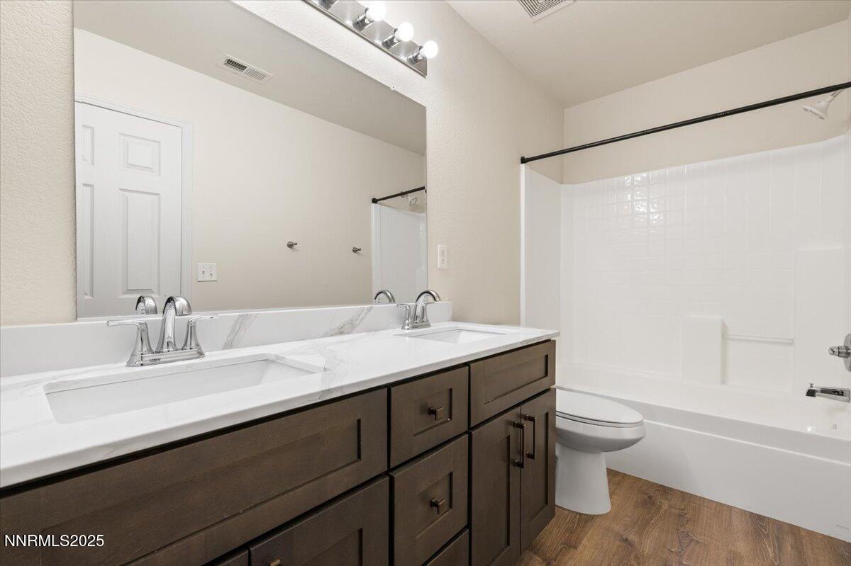 7753 Tulear Street Reno, NV 89506 - Photo 23 of 38 a bathroom with a granite countertop sink toilet a large mirror and shower