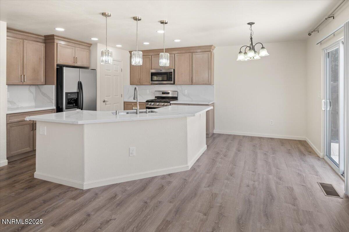 7753 Tulear Street Reno, NV 89506 - Photo 9 of 38 a kitchen with kitchen island white cabinets and refrigerator