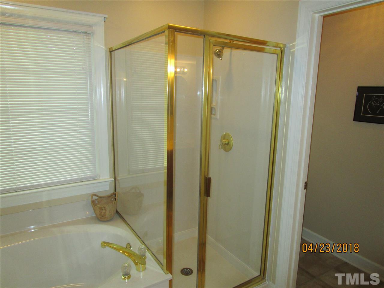 5629 Raddington Street Raleigh, NC 27613 - Photo 14 of 23 a bathroom with a bathtub and a shower